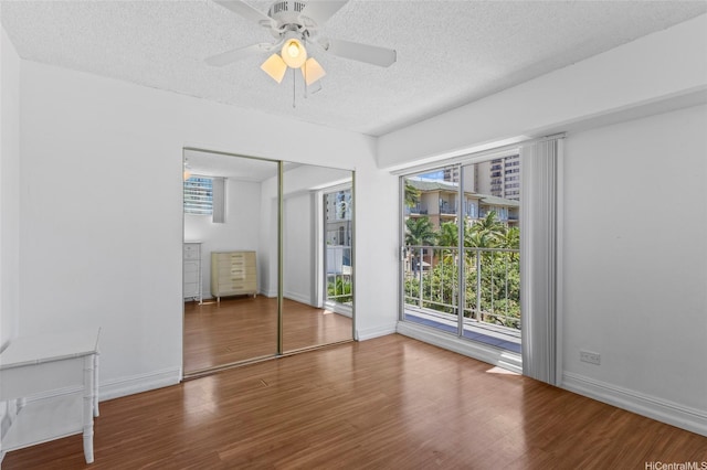 2115 Ala Wai Blvd Unit 501, Honolulu, HI 96815 - unfurnished bedroom featuring a textured ceiling, wood finished floors, multiple windows, and a closet