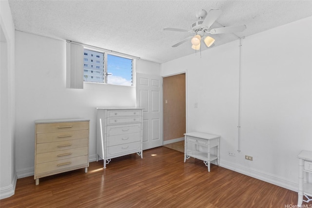 2115 Ala Wai Blvd Unit 501, Honolulu, HI 96815 - unfurnished bedroom with a textured ceiling, wood finished floors, baseboards, and ceiling fan