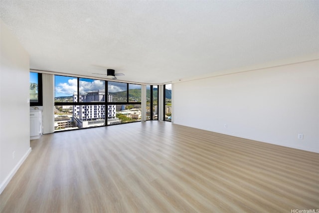 2724 Kahoaloha Ln Unit 1407, Honolulu, HI 96826 - unfurnished living room featuring expansive windows, ceiling fan, wood finished floors, and a textured ceiling