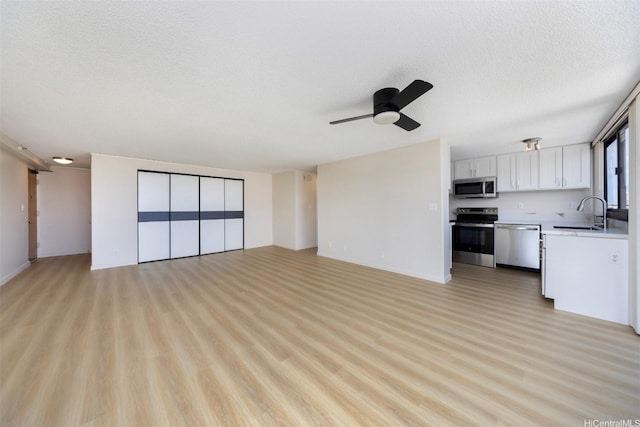 2724 Kahoaloha Ln Unit 1407, Honolulu, HI 96826 - unfurnished living room featuring a sink, a ceiling fan, light wood-style flooring, and a textured ceiling