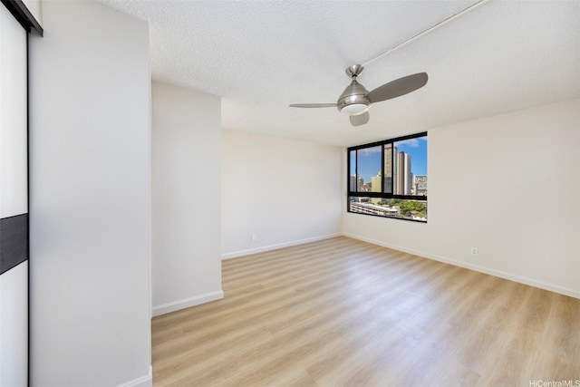 2724 Kahoaloha Ln Unit 1407, Honolulu, HI 96826 - empty room featuring wood finished floors, ceiling fan, baseboards, and a textured ceiling