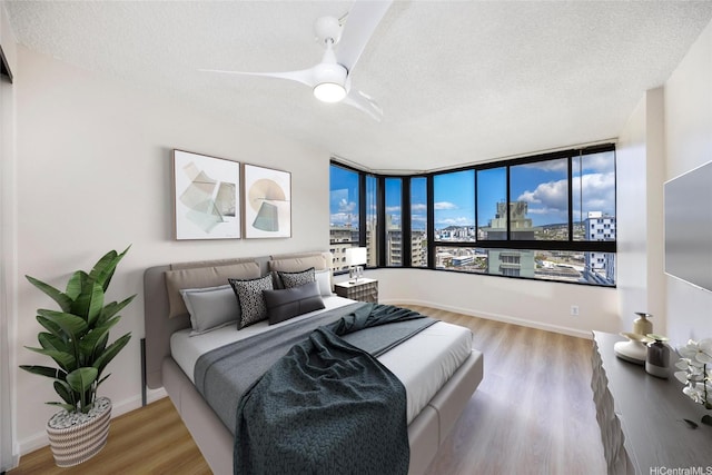 2724 Kahoaloha Ln Unit 1407, Honolulu, HI 96826 - bedroom featuring a textured ceiling, wood finished floors, and a ceiling fan