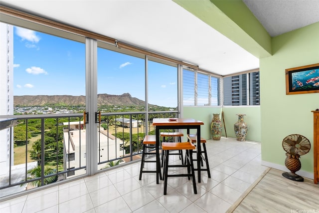 2609 Ala Wai Blvd Unit 1205, Honolulu, HI 96815 - sunroom with a mountain view, a wall of windows, baseboards, and tile patterned flooring