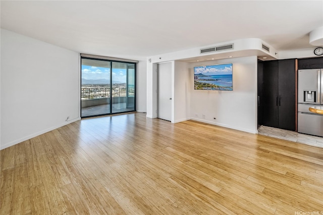 66 Queen St Unit 2904, Honolulu, HI 96813 - empty room featuring a wall of windows and light wood finished floors