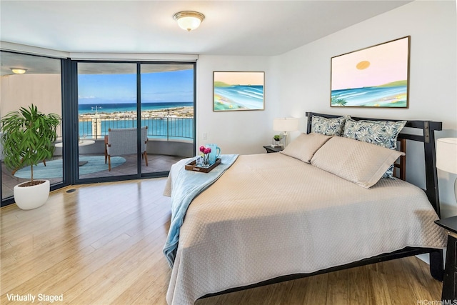 66 Queen St Unit 2904, Honolulu, HI 96813 - bedroom featuring light wood-type flooring, expansive windows, access to exterior, and a water view