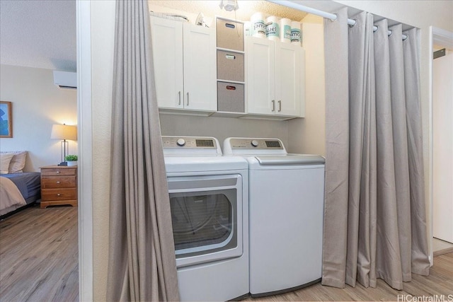 94-457 Akoa Pl, Mililani, HI 96789 - washroom with washing machine and clothes dryer, light wood-type flooring, an AC wall unit, and cabinet space
