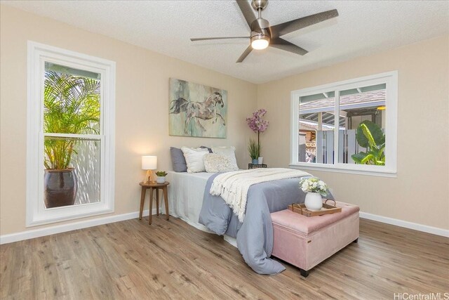 94-457 Akoa Pl, Mililani, HI 96789 - bedroom with baseboards, wood finished floors, a textured ceiling, and a ceiling fan