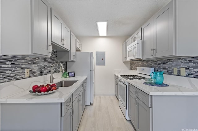 91-1040 Puamaeole St Unit 13R, Ewa Beach, HI 96706 - kitchen featuring white appliances, gray cabinetry, a sink, a textured ceiling, and light wood-style flooring