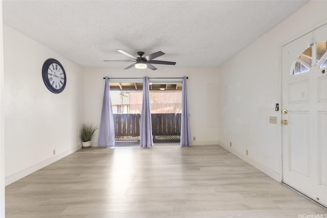 91-1040 Puamaeole St Unit 13R, Ewa Beach, HI 96706 - foyer with ceiling fan, light wood-type flooring, a textured ceiling, and baseboards