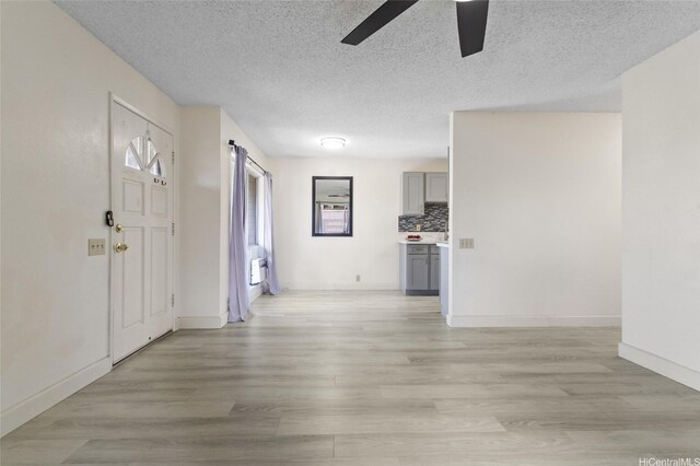 91-1040 Puamaeole St Unit 13R, Ewa Beach, HI 96706 - foyer featuring a ceiling fan, light wood-type flooring, a textured ceiling, and baseboards