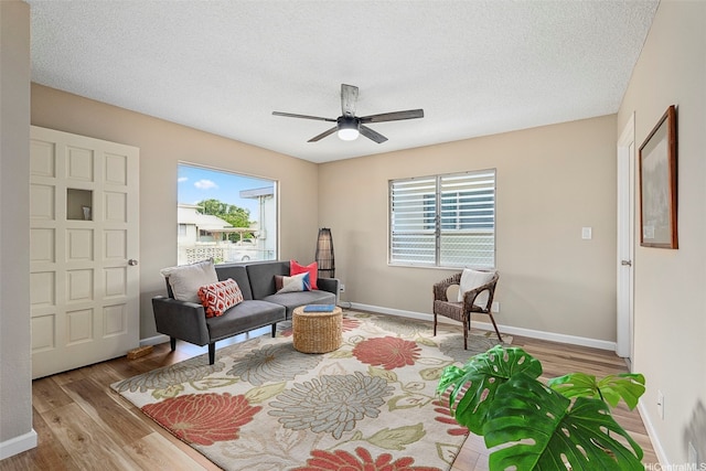 91-1338-A Karayan St, Ewa Beach, HI 96706 - living room featuring wood finished floors, plenty of natural light, a ceiling fan, baseboards, and a textured ceiling