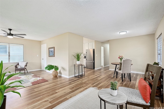 91-1338-A Karayan St, Ewa Beach, HI 96706 - living area with light wood finished floors, plenty of natural light, ceiling fan, a textured ceiling, and baseboards