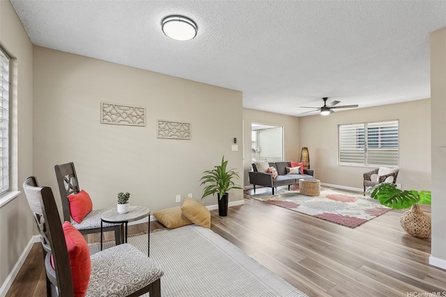 91-1338-A Karayan St, Ewa Beach, HI 96706 - living area with wood finished floors, ceiling fan, baseboards, and a textured ceiling