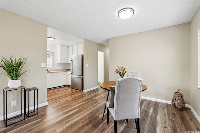 91-1338-A Karayan St, Ewa Beach, HI 96706 - dining area featuring wood finished floors, baseboards, and a textured ceiling