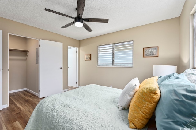 91-1338-A Karayan St, Ewa Beach, HI 96706 - bedroom with wood finished floors, baseboards, ceiling fan, a textured ceiling, and a spacious closet