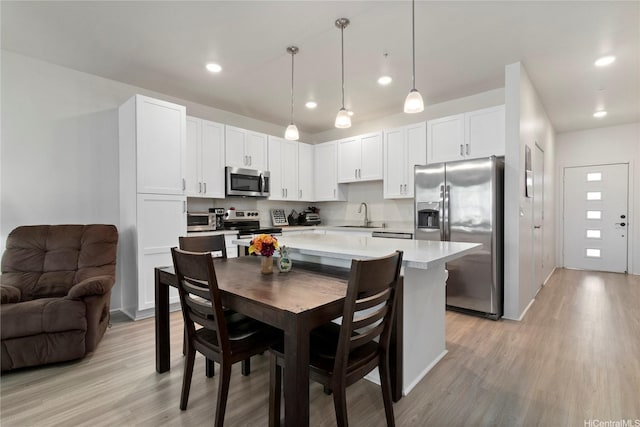 91-3524 Iwikuamoo St Unit 402, Ewa Beach, HI 96706 - kitchen featuring appliances with stainless steel finishes, a sink, light wood-type flooring, light countertops, and white cabinets
