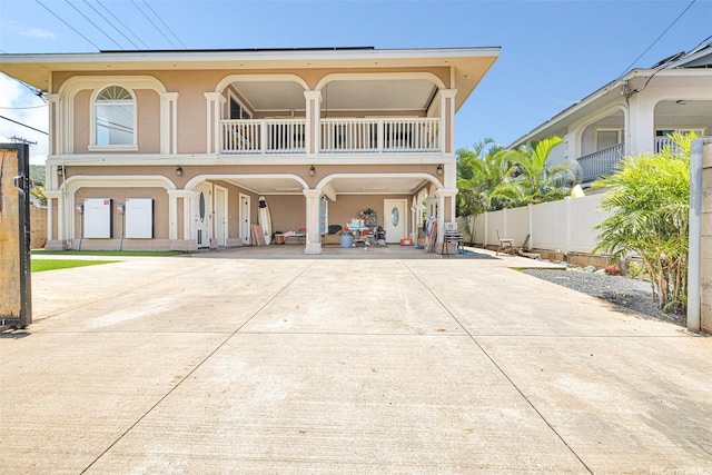 54-220 Kaipapau Loop, Hauula, HI 96717 - view of front facade with driveway, a balcony, a carport, and stucco siding