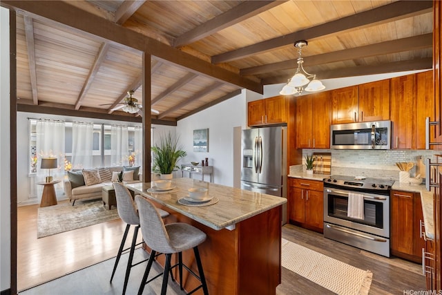 87-217 Maia St, Waianae, HI 96792 - kitchen featuring appliances with stainless steel finishes, tasteful backsplash, light stone countertops, brown cabinetry, and wooden ceiling