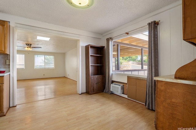 92-742 Nohopono St, Kapolei, HI 96707 - unfurnished dining area with light wood-type flooring, a textured ceiling, an AC wall unit, and a ceiling fan