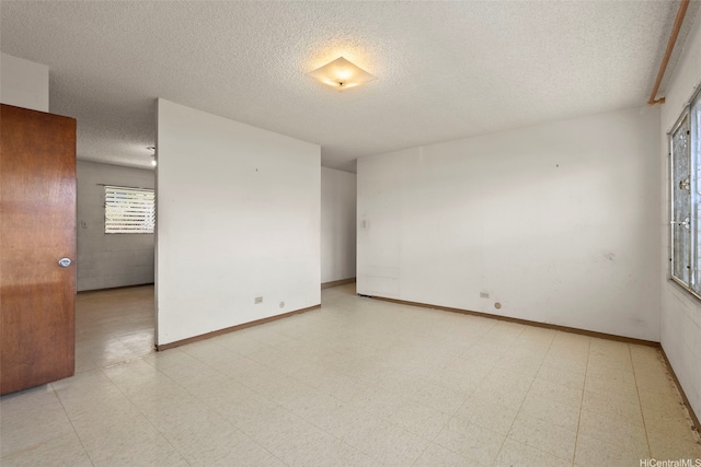 94-533 Ulieo St, Waipahu, HI 96797 - empty room featuring a textured ceiling, light floors, and baseboards