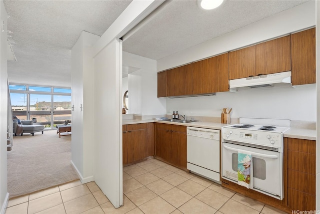 500 University Ave Unit 532, Honolulu, HI 96826 - kitchen with white appliances, under cabinet range hood, a sink, brown cabinetry, and light countertops