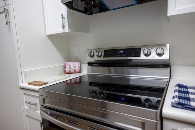 255 Mananai Pl Unit 52T, Honolulu, HI 96818 - kitchen featuring stainless steel electric range oven, white cabinetry, light countertops, and exhaust hood