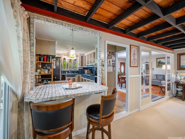 509 Lawelawe St, Honolulu, HI 96821 - kitchen featuring freestanding refrigerator, a sink, light colored carpet, a peninsula, and tile counters