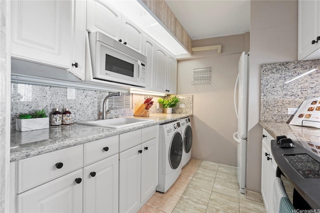 2333 Kapiolani Blvd Unit 2211, Honolulu, HI 96826 - kitchen featuring white appliances, a sink, separate washer and dryer, backsplash, and white cabinetry