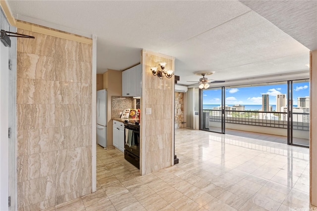 2333 Kapiolani Blvd Unit 2211, Honolulu, HI 96826 - kitchen with freestanding refrigerator, ceiling fan, black range oven, a textured ceiling, and white cabinetry