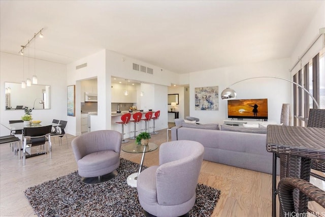 229 Paoakalani Ave Unit Ph-3807, Honolulu, HI 96815 - living area featuring light wood-style floors and track lighting