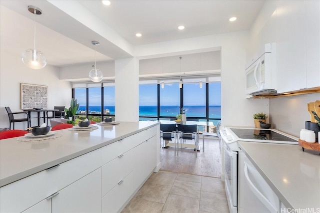229 Paoakalani Ave Unit Ph-3807, Honolulu, HI 96815 - kitchen with white appliances, light countertops, white cabinets, a water view, and decorative light fixtures