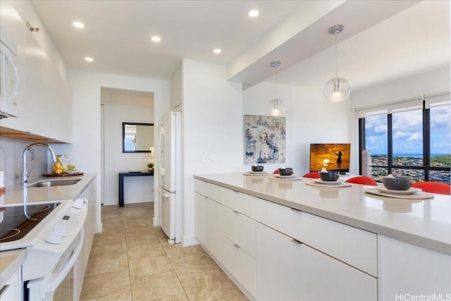 229 Paoakalani Ave Unit Ph-3807, Honolulu, HI 96815 - kitchen with white appliances, light countertops, white cabinetry, recessed lighting, and decorative light fixtures