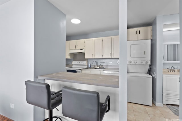 909 Ala Nanala St Unit 1401, Honolulu, HI 96818 - kitchen with stacked washer / dryer, white range with electric stovetop, a kitchen bar, a sink, and under cabinet range hood