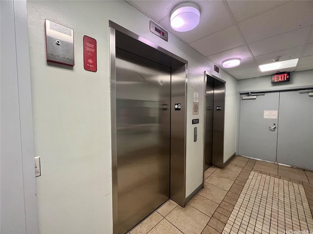 94-302 Paiwa St Unit 201, Waipahu, HI 96797 - hall featuring light tile patterned floors, elevator, and a paneled ceiling