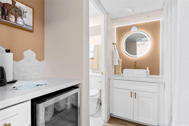 2450 Prince Edward St Unit 1006A, Honolulu, HI 96815 - full bathroom featuring beverage cooler, vanity, toilet, and decorative backsplash