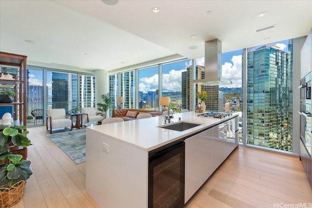 1118 Ala Moana Blvd Unit 2505, Honolulu, HI 96814 - kitchen with wine cooler, expansive windows, a sink, a city view, and island range hood