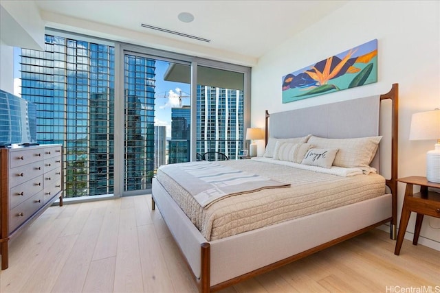 1118 Ala Moana Blvd Unit 2505, Honolulu, HI 96814 - bedroom featuring expansive windows, wood finished floors, and access to outside