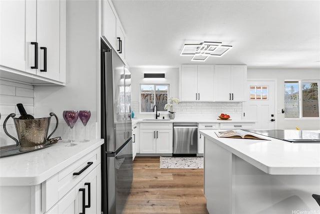 85-310 Kohai Pl, Waianae, HI 96792 - kitchen with appliances with stainless steel finishes, tasteful backsplash, light wood-style floors, a sink, and light countertops