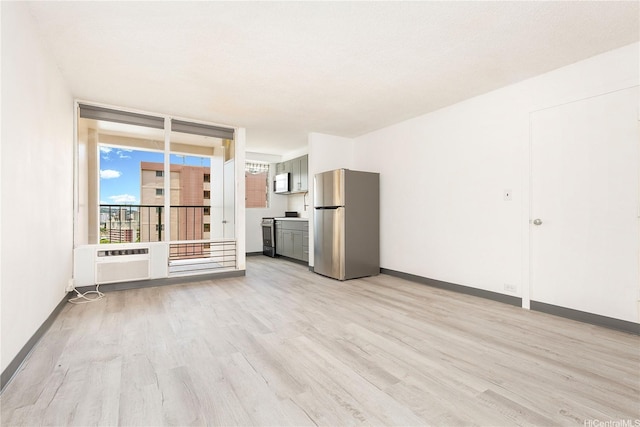 747 Amana St Unit 1607, Honolulu, HI 96814 - unfurnished living room with light wood-style floors and a wall mounted air conditioner