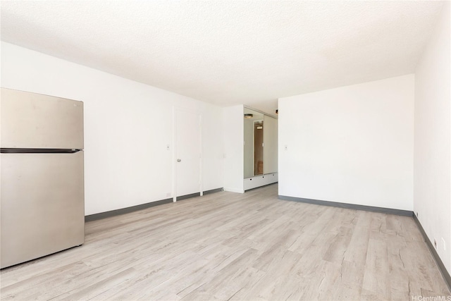 747 Amana St Unit 1607, Honolulu, HI 96814 - spare room featuring light wood-type flooring and a textured ceiling
