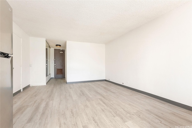 747 Amana St Unit 1607, Honolulu, HI 96814 - empty room with light wood-type flooring and a textured ceiling