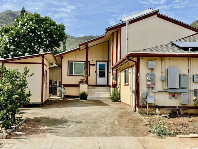 790 Ipuai St, Honolulu, HI 96825 - rear view of house with a mountain view, roof mounted solar panels, a shingled roof, and an outbuilding