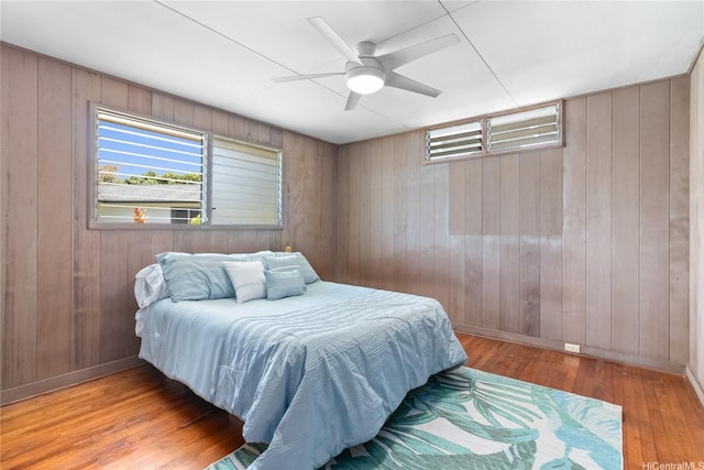 45-258 Halemuku Pl, Kaneohe, HI 96744 - bedroom featuring multiple windows, wood-type flooring, wooden walls, baseboards, and a ceiling fan