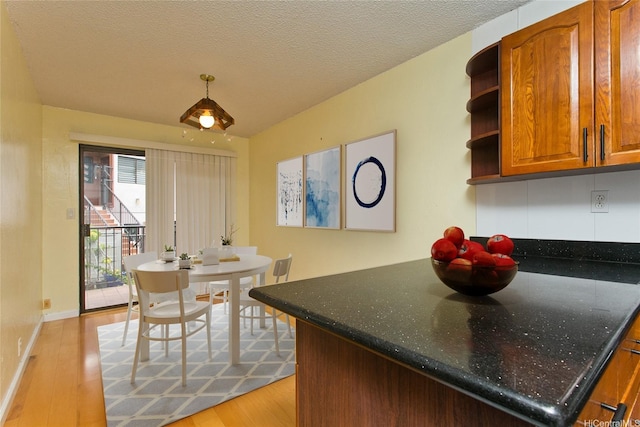 98-364 Kaonohi St Unit 11386, Aiea, HI 96701 - kitchen featuring light wood-style flooring, open shelves, brown cabinetry, baseboards, and a textured ceiling
