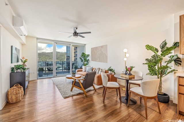 1391 Kapiolani Blvd Unit 3402, Honolulu, HI 96814 - sitting room with a wall of windows, a ceiling fan, wood finished floors, a wall unit AC, and baseboards