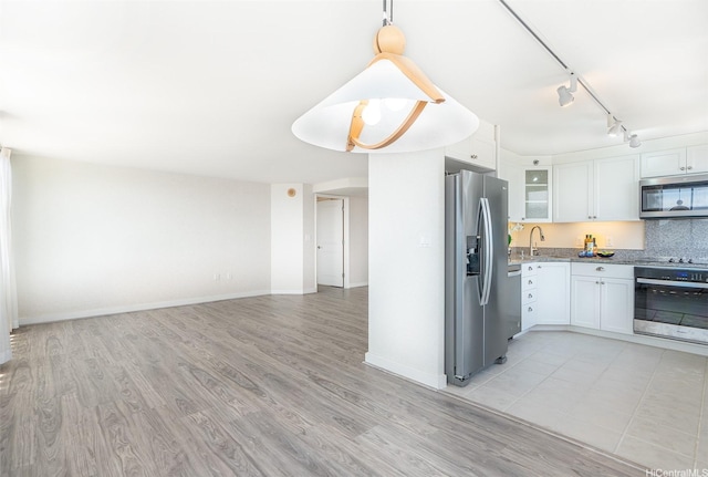 343 Hobron Ln Unit 4302, Honolulu, HI 96815 - kitchen with appliances with stainless steel finishes, white cabinetry, light wood-style flooring, track lighting, and light stone countertops