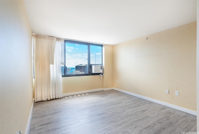 343 Hobron Ln Unit 4302, Honolulu, HI 96815 - unfurnished room with wood finished floors, baseboards, and cooling unit