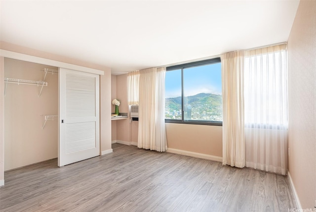 343 Hobron Ln Unit 4302, Honolulu, HI 96815 - unfurnished bedroom featuring wood finished floors, a closet, baseboards, and a mountain view