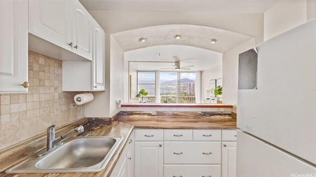 949 Ala Nanala St Unit 1201, Honolulu, HI 96818 - kitchen with freestanding refrigerator, a sink, white cabinetry, and tasteful backsplash