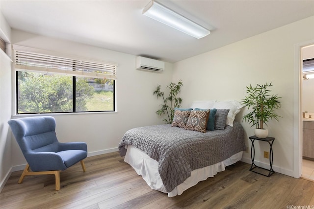 98-130 Lania Way Unit 42, Aiea, HI 96701 - bedroom with a wall mounted AC, wood finished floors, baseboards, and connected bathroom